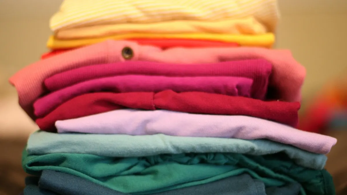 Pilha de roupas coloridas dobradas sobre fundo claro